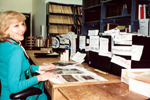 Lillian Michaelson works at a desk covered with papers