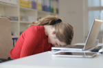 Tired woman rests her head on her laptop (Photo: Andrea Piacquadio/Pexels)