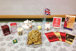 The Masterpiece Book Club at Chicago Public Library’s Vodak–East Side branch hosted a Miss Fisher–themed holiday party in 2015. (Photo: Table set with books, postcards, teapot, scones, and Union Jack flags)