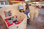 A workstation with a baby in an attached play area