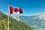 Canadian flag flying over a mountain