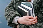 An arm holding books