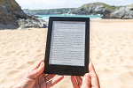 Person reading ebook on beach
