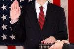 Person in suit with one hand raised