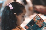 Young girl examining a book at a book fair
