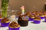 Cupcakes, one of which has a 1-shaped candle and the words happy birthday.