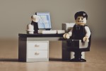 Lego figure of a frustrated worker at a desk