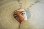 Eye peering into a book with pages curved to form a tunnel