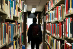 Silhouette of a boy in a library aisle