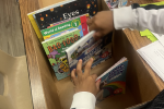 Child's hands looking through a box of books