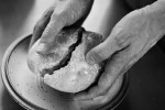 Pair of hands splitting up a loaf of bread