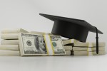 Graduation cap atop a pile of money
