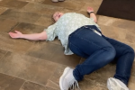 Woman sprawled on the ground after a failed trust fall in a New Berlin Public Library promotional video