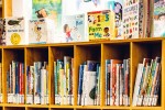 Children's books on a packed bookshelf