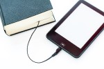 Tablet computer with charging cord that leads into a printed book