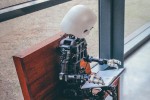 Robot on bench reading