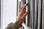 Hand reaching for books on a shelf