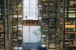 Interior of a library with tall metal shelves and reflections that make it resemble a computer chip