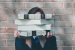 Woman holding books to obscure her face