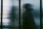 Silhouette of someone seen through a window