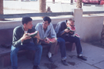 Three men sitting in an image that required human intervention to generate adequate metadata