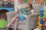 Girl reading in a comfortable library chair