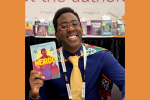 Tony Weaver Jr. holding a copy of his book Weirdo.