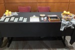 Check-in table with a black tablecloth and spiderweb decorations.
