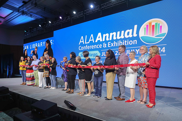 ALA Executive Board members and others hold a ribbon while ALA President Emily Drabinski cuts it